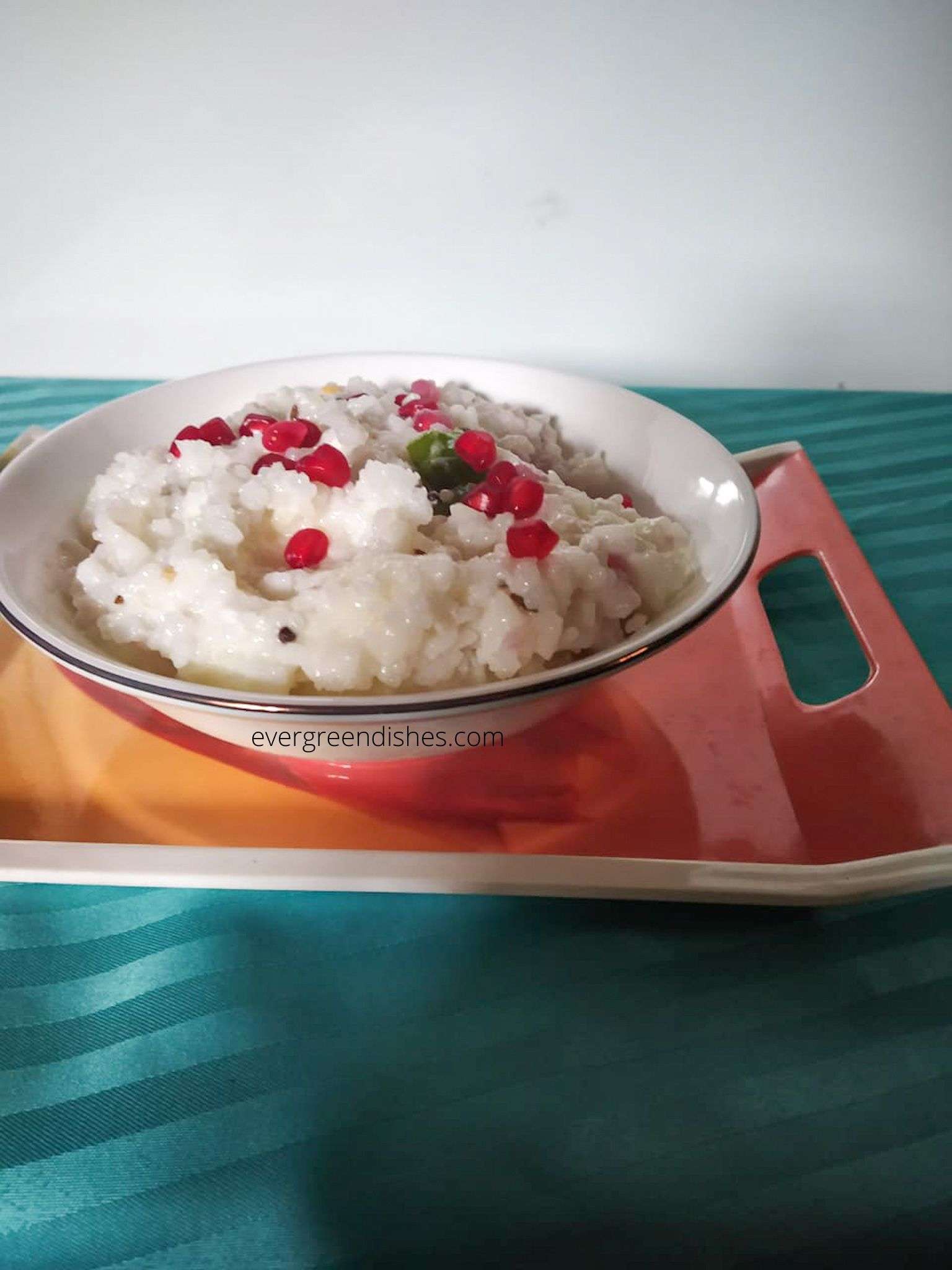 a bowl of curd rice garnished with pomegranate arils